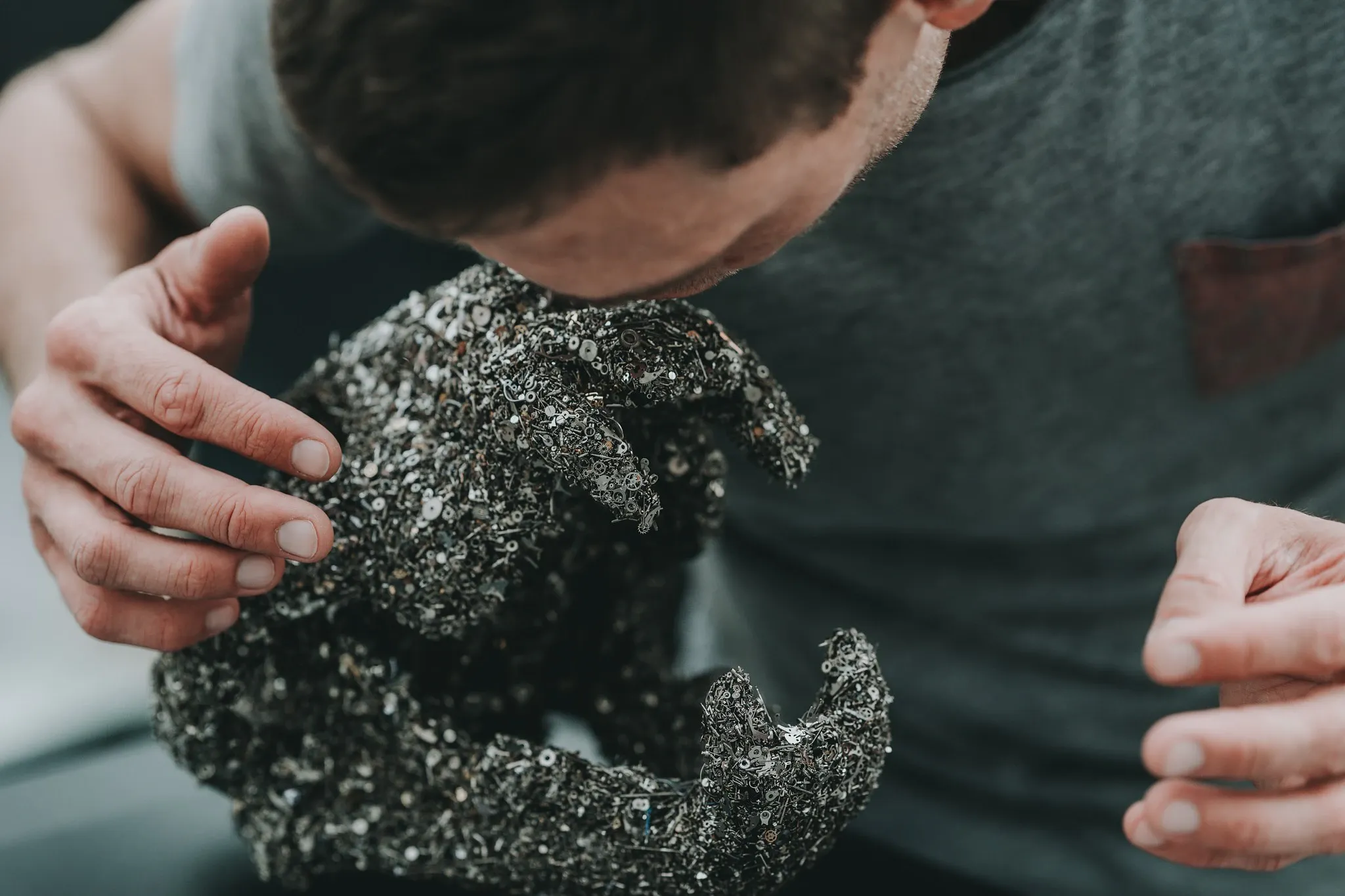 Main et sculpture textile au cadrage rapproché.