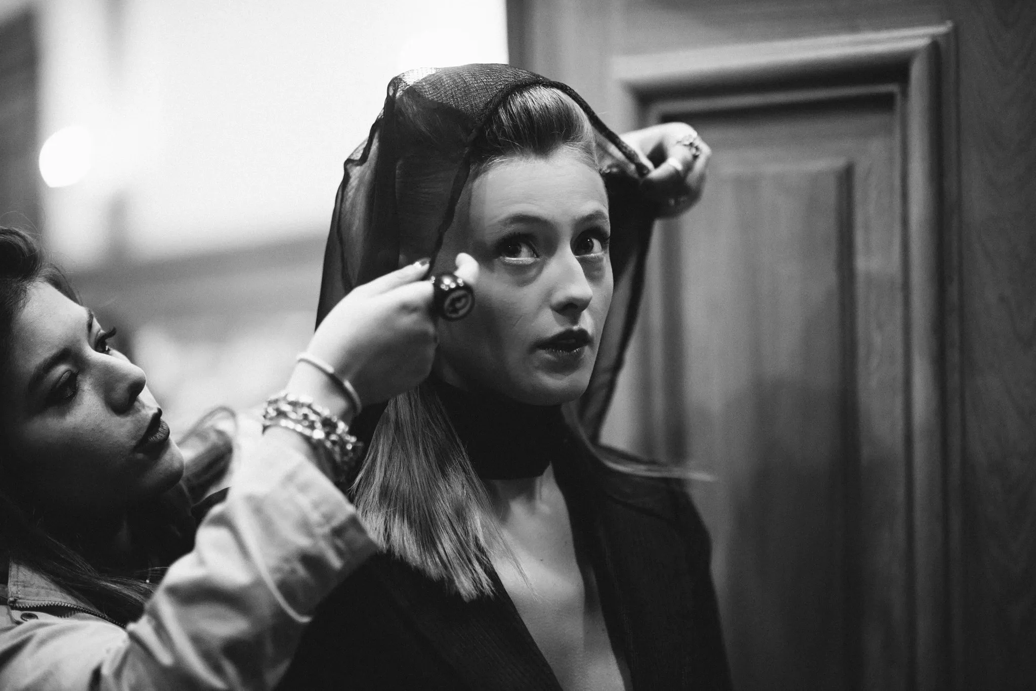 Préparation d'un modèle dans un intérieur sobre, en noir et blanc.